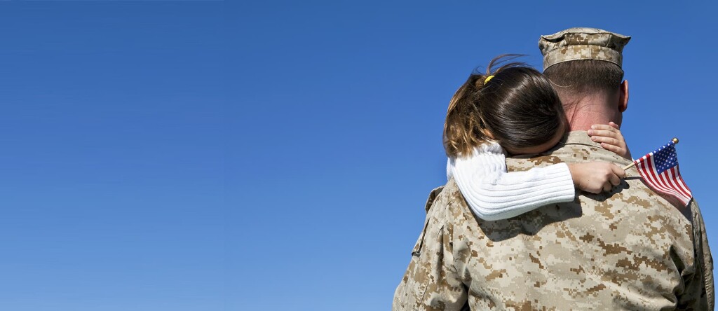 MIlitary member huggung child